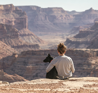 Girl sitting with arm around dog in the canyons